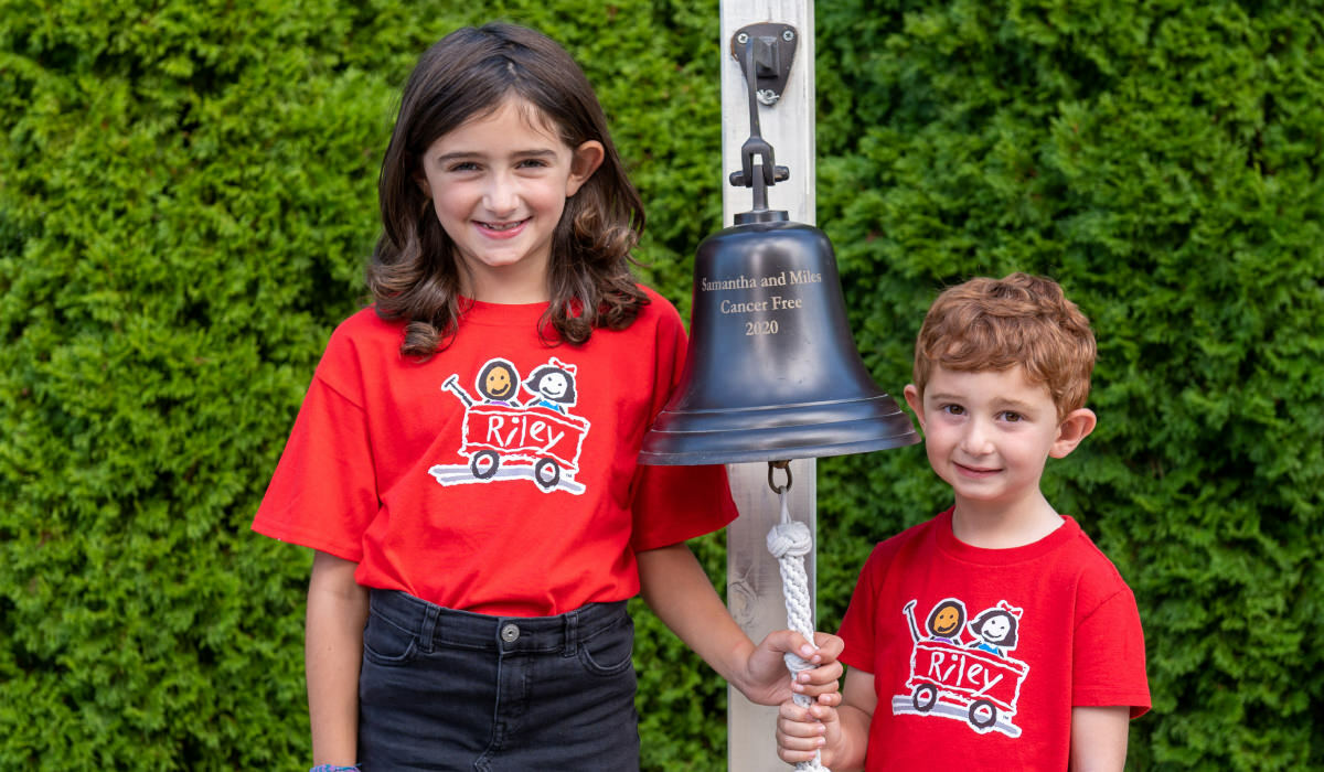 Samantha & Miles Standing Next To Their Commemorative Bell