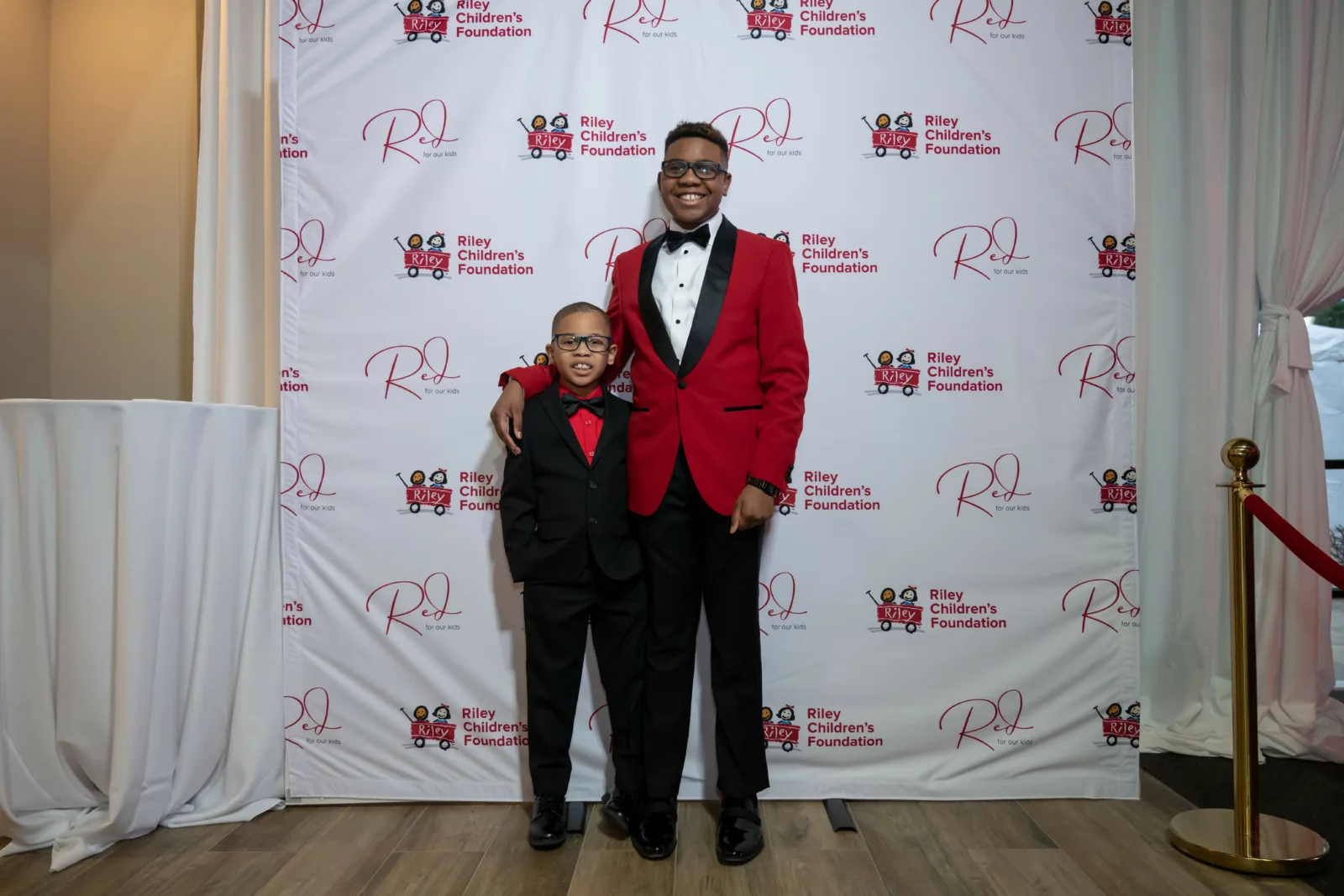 Riley kids in front of backdrop with Riley logos at Riley Red event