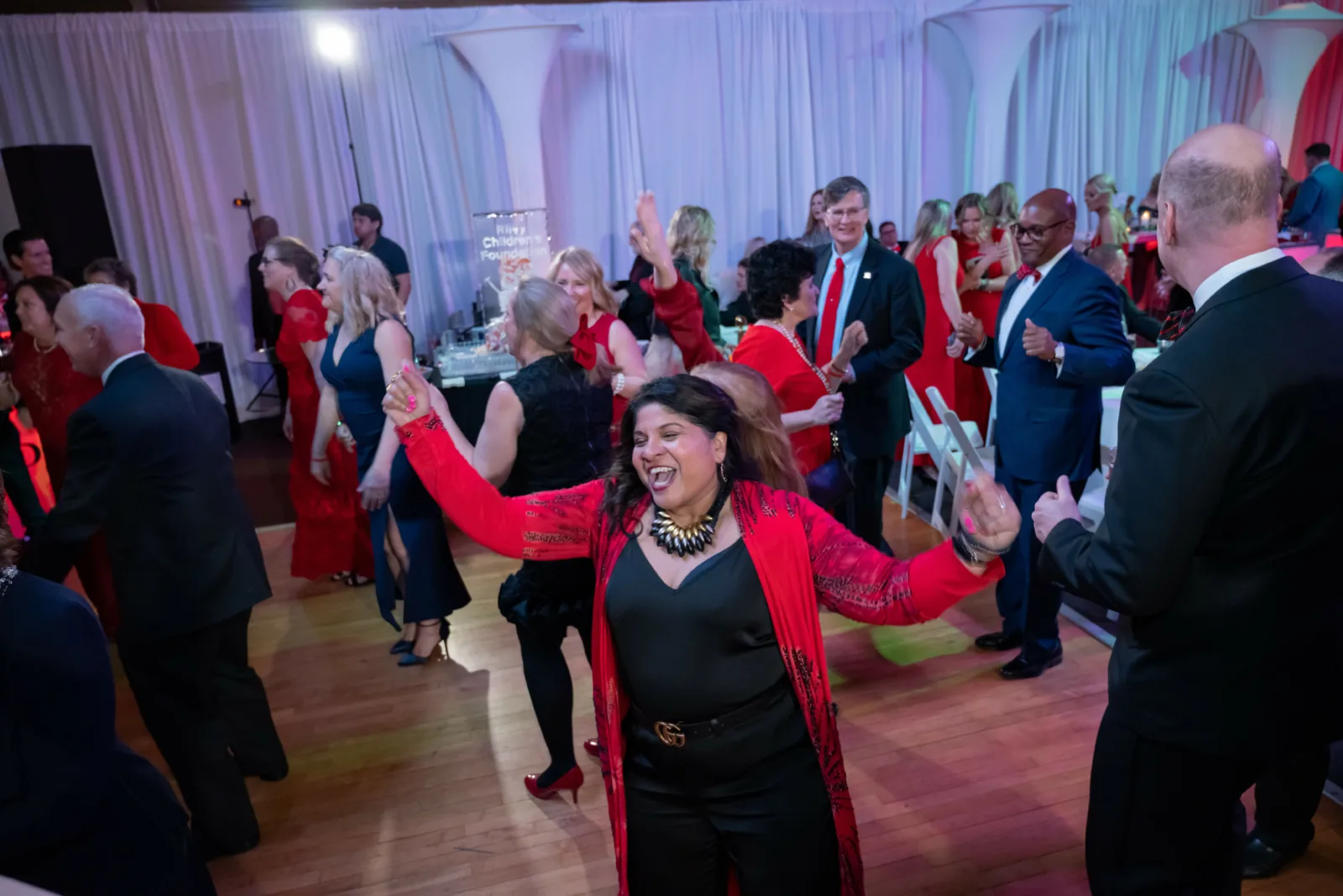 Woman dancing on the ballroom at the Riley Red event.