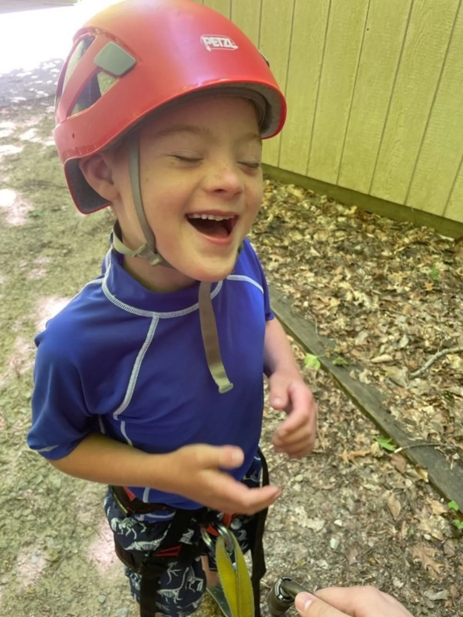 Luke laughing wearing a climbing helmet and gear