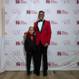 Riley kids in front of backdrop with Riley logos at Riley Red event