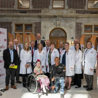 Walther Cancer Foundation researchers, guests, and administrators pose for photo on stage