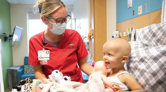Riley nurse with Riley oncology patient in Riley Hospital room.