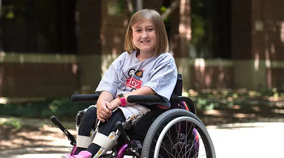 Riley kid, Addyson Wooldridge in wheelchair outside of Riley Hospital