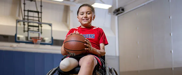 Jonathin Perez in a wheelchair holding a basketball