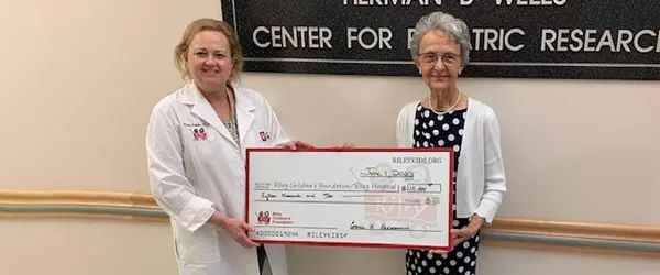 Connie Radovanovic with giant check and researcher