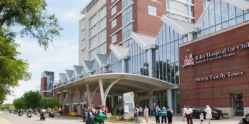 Motorcyclists ride past Riley Hospital for Children while patients and families watch and wave.