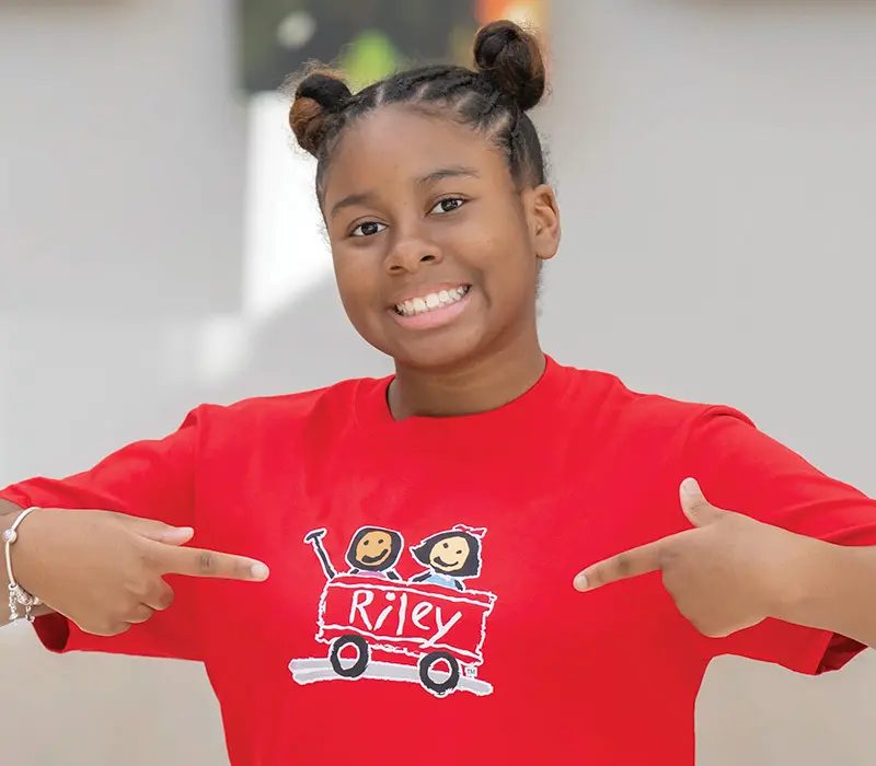 Calina points at Riley logo on her shirt.